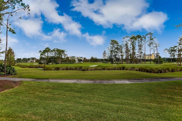 view of property's community featuring golf course view and a lawn