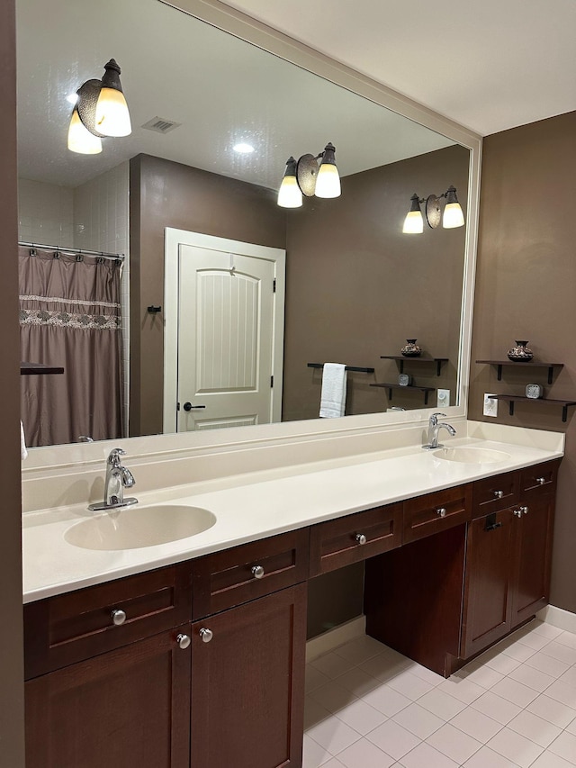 bathroom with double vanity, visible vents, and a sink