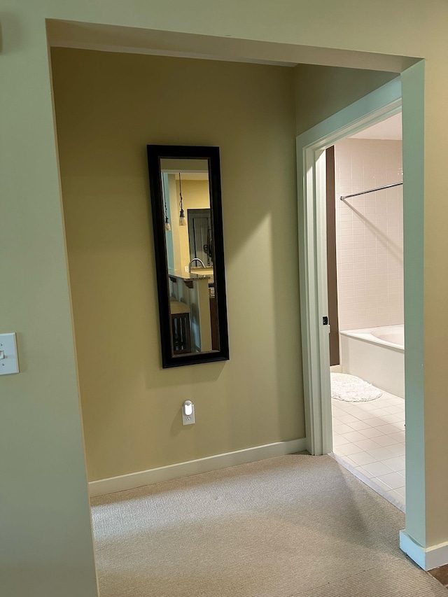 corridor with baseboards and carpet floors