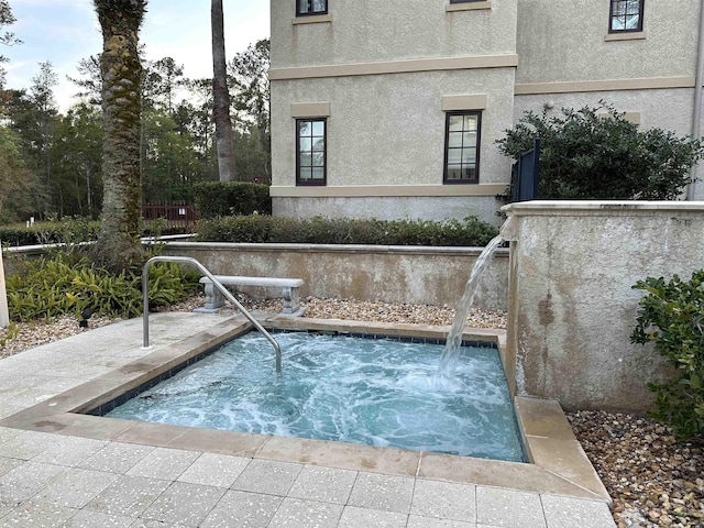 view of pool with an in ground hot tub