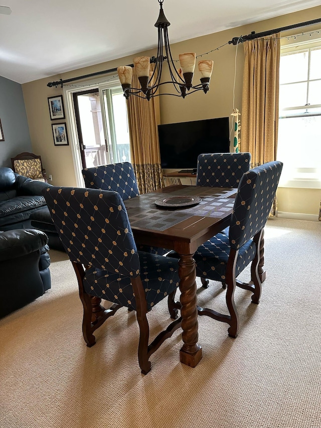 carpeted dining room with a wealth of natural light and a chandelier