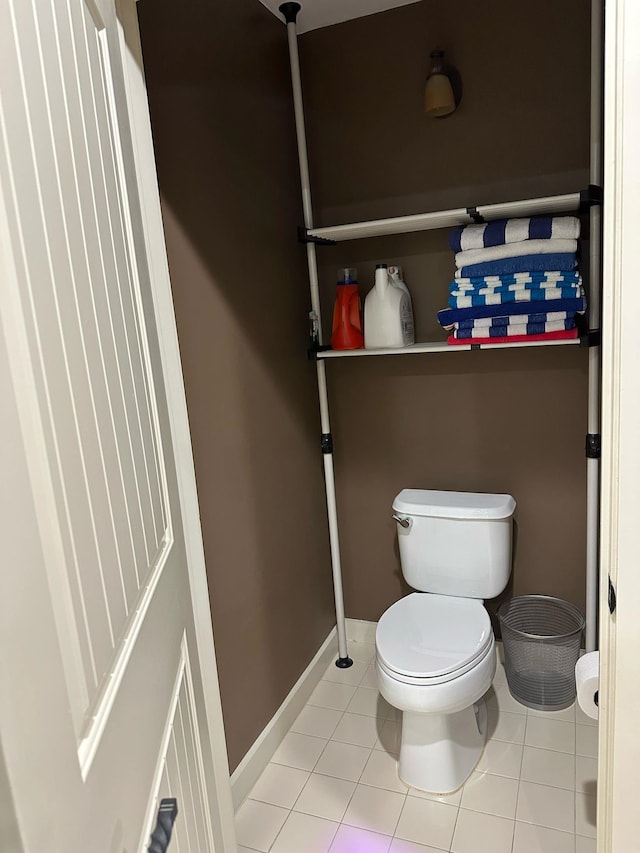 bathroom featuring tile patterned floors, toilet, and baseboards