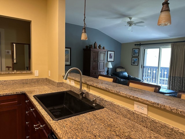 kitchen featuring a sink, ceiling fan, vaulted ceiling, and hanging light fixtures