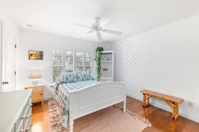 bedroom with ceiling fan, light wood finished floors, and baseboards