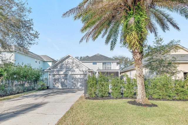 view of front facade with driveway, an attached garage, fence, and a front yard