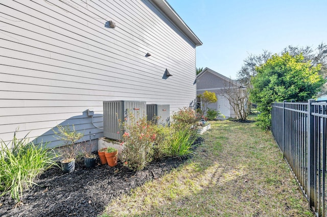 view of yard featuring central AC unit and fence