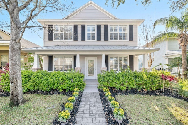 traditional style home featuring covered porch, metal roof, and a standing seam roof