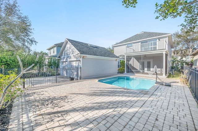 view of swimming pool with a patio, fence, a fenced in pool, and an outdoor structure