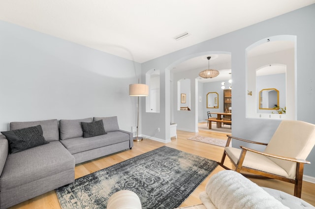 living area featuring wood finished floors, visible vents, and baseboards