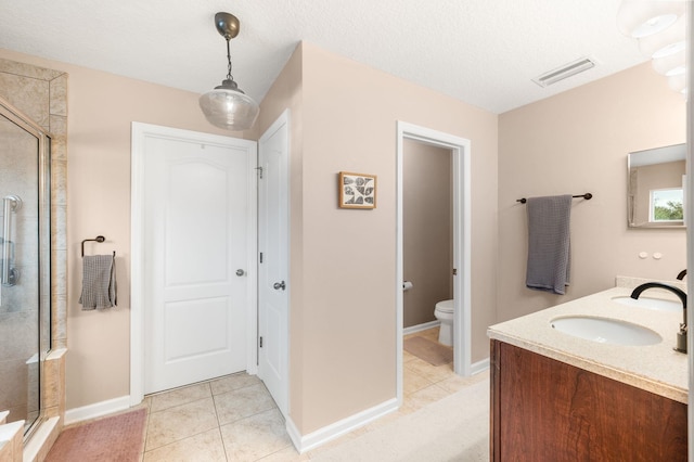 full bath featuring a stall shower, tile patterned flooring, a sink, and toilet