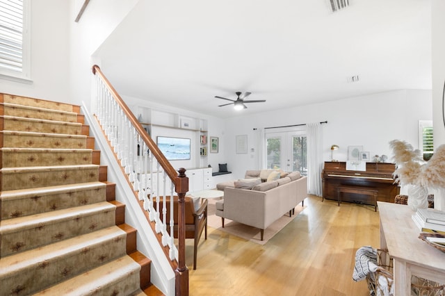 living room with visible vents, a ceiling fan, stairs, french doors, and light wood-type flooring