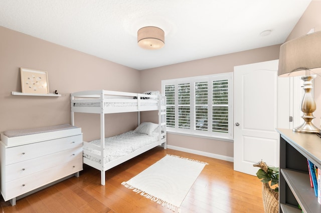 bedroom with baseboards and wood finished floors