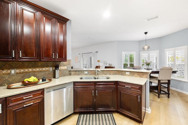 kitchen featuring visible vents, decorative backsplash, a peninsula, stainless steel dishwasher, and a sink