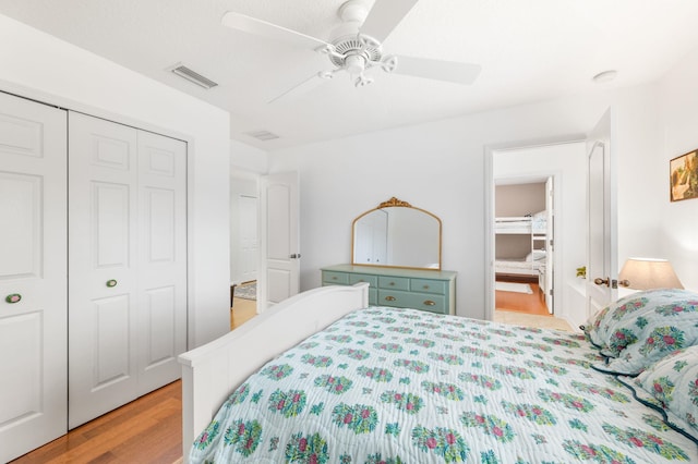 bedroom featuring a ceiling fan, visible vents, a closet, and wood finished floors