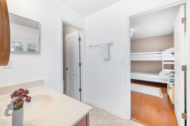 bathroom with tile patterned flooring, vanity, and baseboards