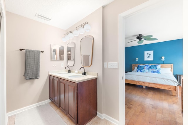 full bath featuring baseboards, visible vents, connected bathroom, and a sink