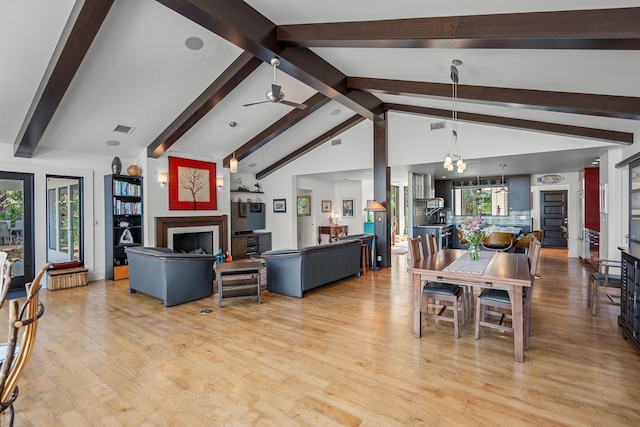 dining room with a ceiling fan, visible vents, vaulted ceiling with beams, and light wood-style floors