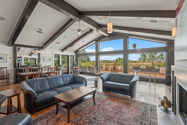 living area featuring visible vents, wood finished floors, a fireplace, and beamed ceiling