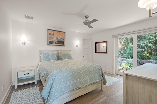 bedroom featuring baseboards, access to outside, wood finished floors, and visible vents