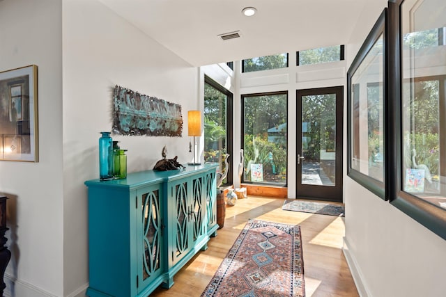 doorway to outside featuring baseboards, recessed lighting, light wood-style flooring, and visible vents