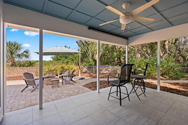 view of patio with ceiling fan and an outdoor fire pit