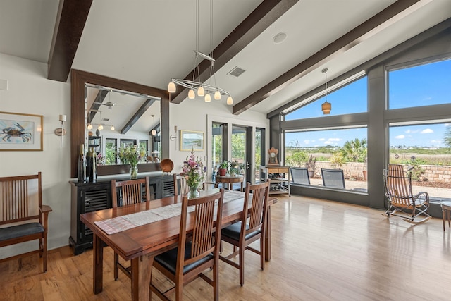 dining area with high vaulted ceiling, plenty of natural light, beamed ceiling, and light wood finished floors