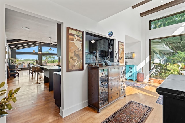 interior space featuring baseboards, wood finished floors, and vaulted ceiling