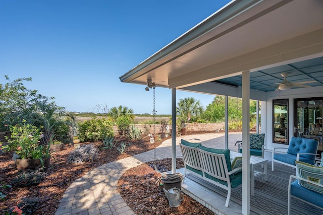 view of patio featuring fence, ceiling fan, and outdoor lounge area