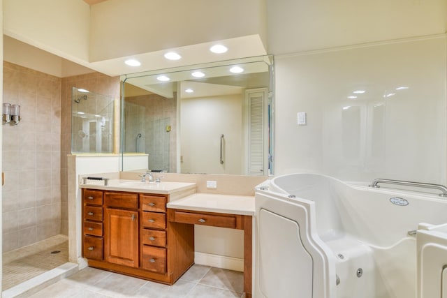 bathroom featuring a tile shower, tile patterned flooring, a jetted tub, and vanity