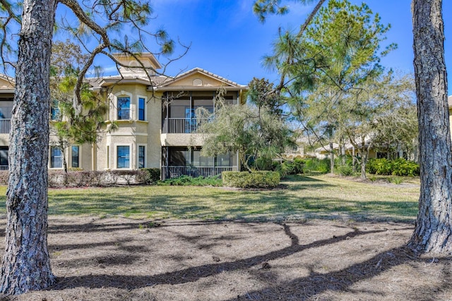 view of front of home featuring stucco siding and a front lawn