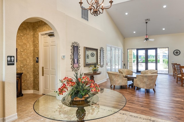 dining room featuring high vaulted ceiling, wood finished floors, recessed lighting, arched walkways, and baseboards