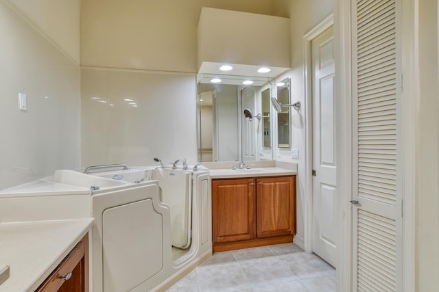 bathroom featuring tile patterned flooring, washer / dryer, a bath, a closet, and vanity