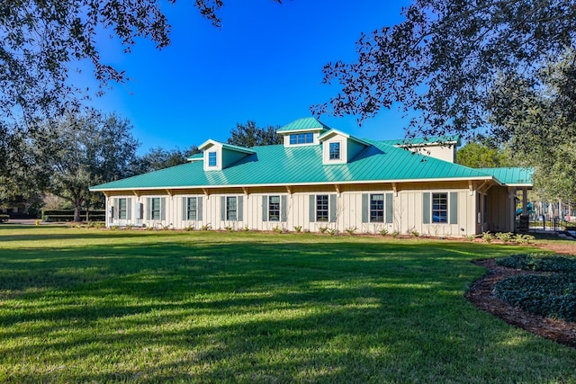 back of house featuring metal roof, a lawn, board and batten siding, and a standing seam roof