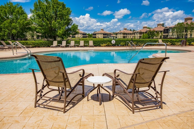 pool featuring a patio area, a residential view, and fence