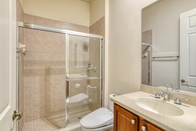 bathroom featuring a stall shower, toilet, and vanity