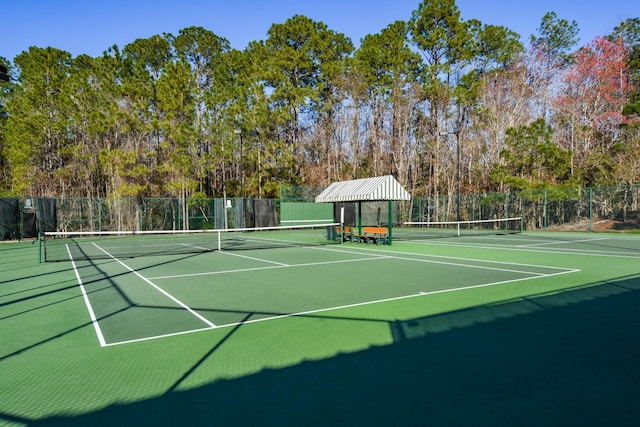 view of tennis court with community basketball court and fence