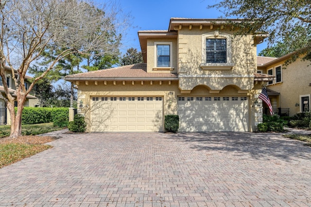 view of front of property with a tiled roof, decorative driveway, and stucco siding