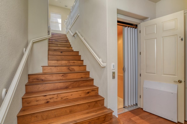 stairway with wood finished floors