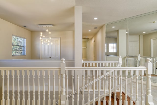 corridor featuring recessed lighting, visible vents, and an upstairs landing