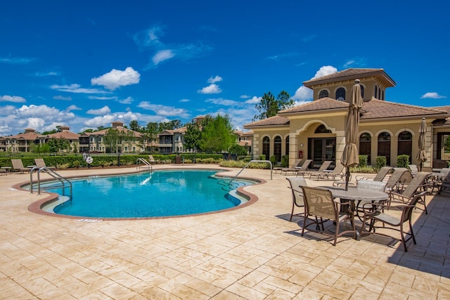 pool with a patio and fence