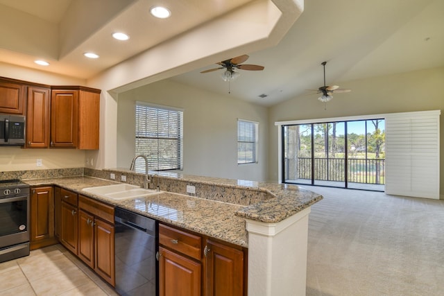 kitchen with a peninsula, ceiling fan, stainless steel appliances, a sink, and open floor plan