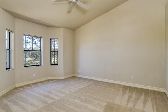 unfurnished room with a ceiling fan, baseboards, and light carpet