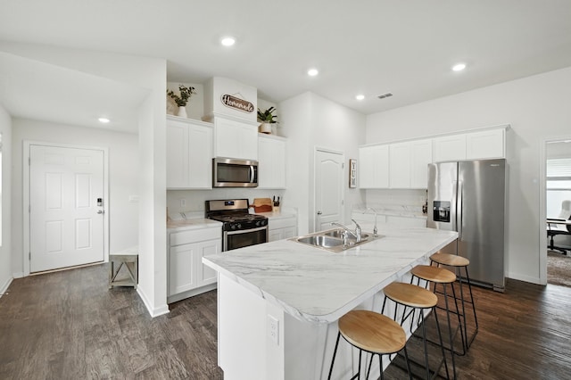 313 Caminha Rd, Saint Augustine, FL 32084 - kitchen featuring appliances with stainless steel finishes, an island with sink, dark wood-style floors, a breakfast bar, and recessed lighting