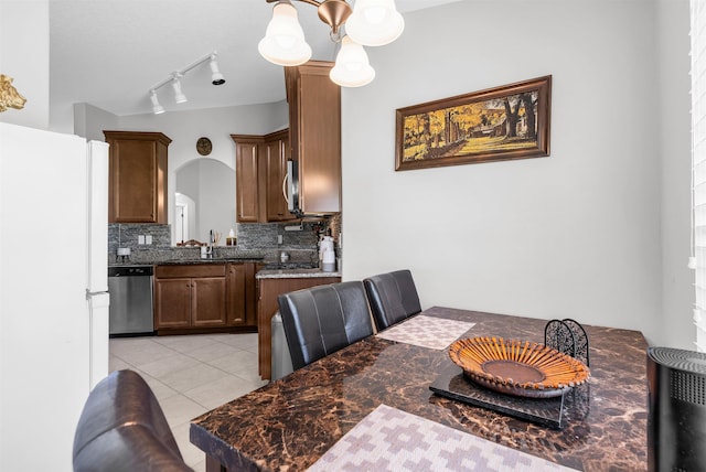 4 Contee Ct, Palm Coast, FL 32137 - dining space featuring arched walkways, light tile patterned floors, a chandelier, and rail lighting