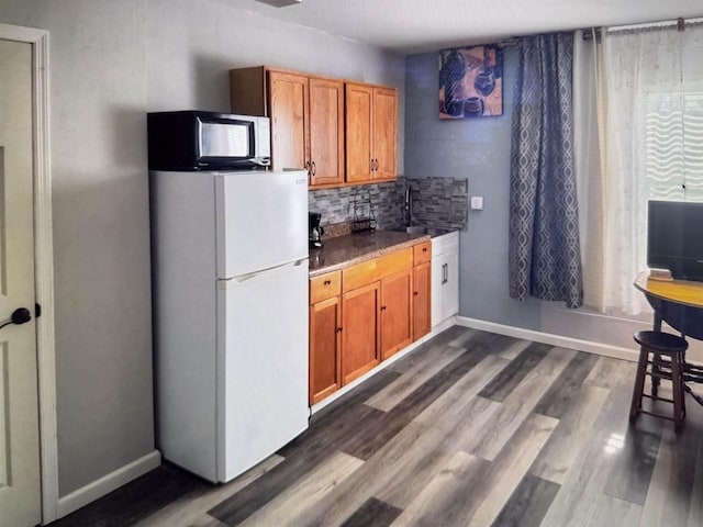 4 Contee Ct, Palm Coast, FL 32137 - kitchen with freestanding refrigerator, a sink, brown cabinetry, dark wood finished floors, and tasteful backsplash