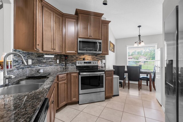 4 Contee Ct, Palm Coast, FL 32137 - kitchen featuring appliances with stainless steel finishes, a sink, backsplash, and brown cabinets