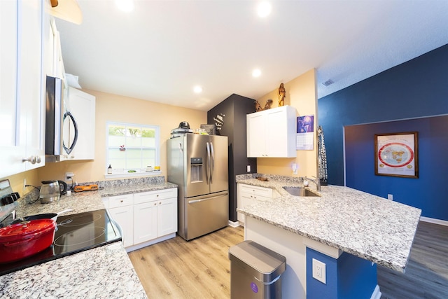 4420 Cedar Ford Blvd, Hastings, FL 32145 - kitchen featuring appliances with stainless steel finishes, a peninsula, light wood-style floors, white cabinets, and light stone counters