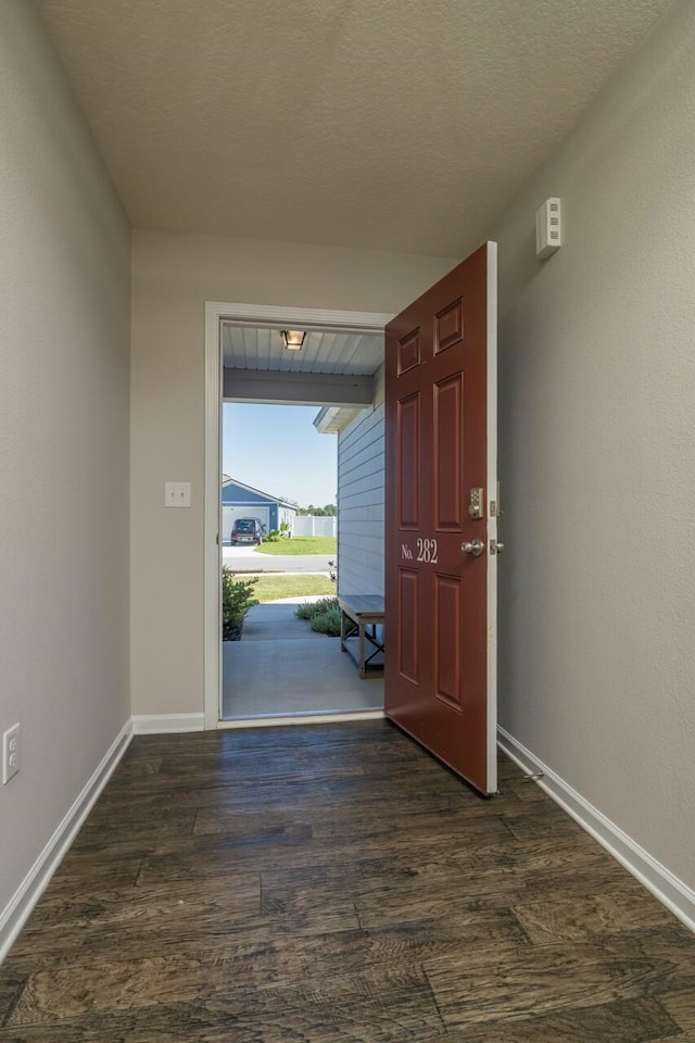 foyer entrance featuring a textured ceiling and dark hardwood / wood-style flooring