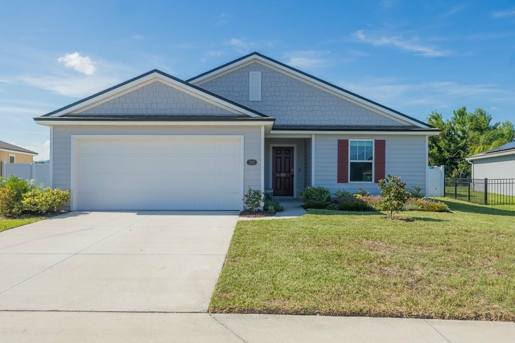 view of front of home with a garage and a front lawn