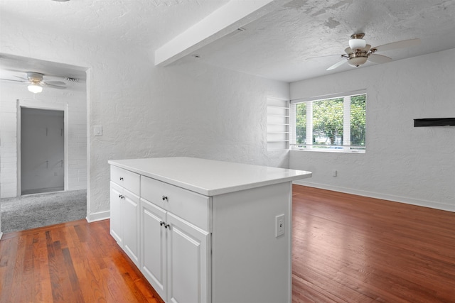 1316 NE 9th St, Gainesville, FL 32605 - kitchen featuring a ceiling fan, a textured wall, wood finished floors, white cabinets, and light countertops